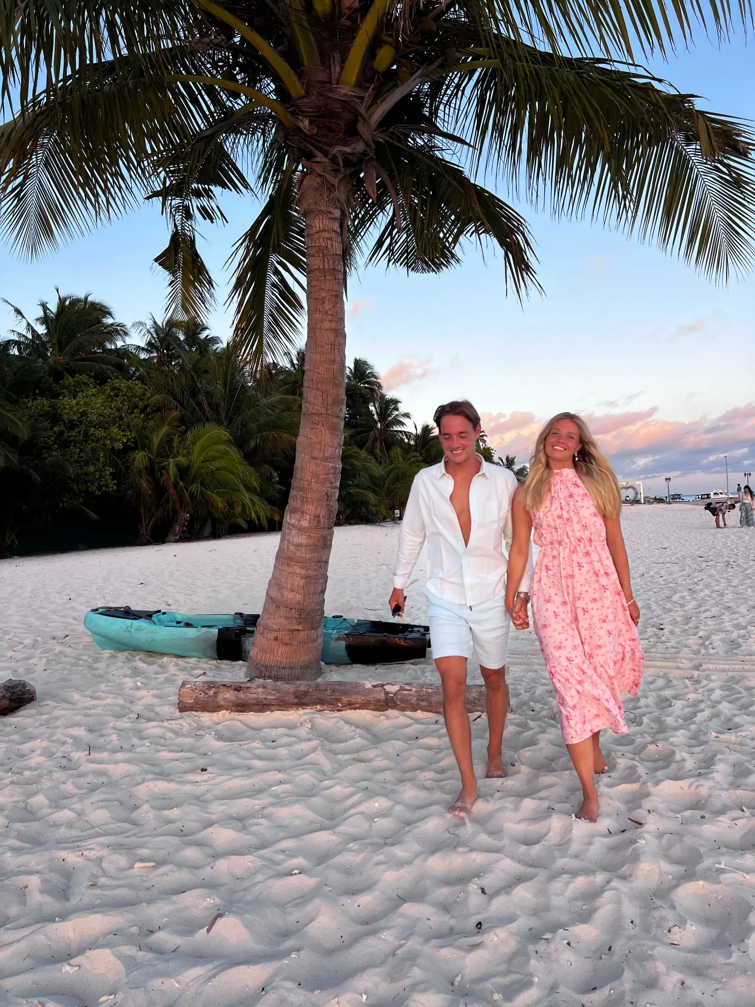 Jan and Emma walking together on a tropical beach